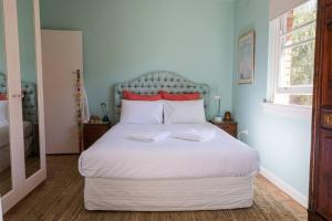 - une chambre avec un grand lit blanc et des oreillers rouges dans l'établissement Art Deco at Marouba Beach - Soak up the Sand & Surf, à Sydney