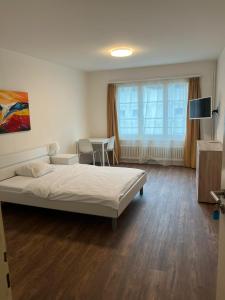 a bedroom with a bed and a table with chairs at Zimmer mit geteiltem Bad & Küche in Brugg