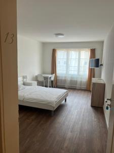 sypialnia z łóżkiem, stołem i oknem w obiekcie Zimmer mit geteiltem Bad & Küche w mieście Brugg