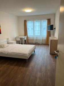 1 dormitorio con 1 cama y 1 mesa con sillas en Zimmer mit geteiltem Bad & Küche en Brugg