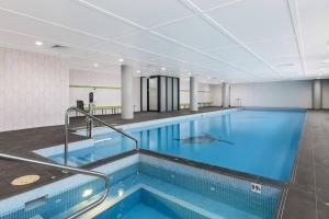 een zwembad in een gebouw met een groot zwembad bij 'Eastgardens Splendour' Two-storey Style with Pool in Sydney