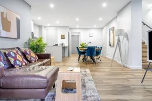 een woonkamer met een bank en een tafel bij 'Eastgardens Splendour' Two-storey Style with Pool in Sydney