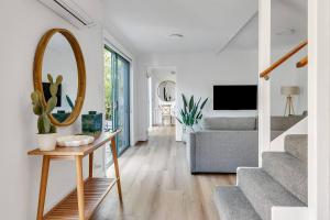 een woonkamer met een spiegel en een bank bij Bronte Haven - Coastal Bliss for Families in Sydney