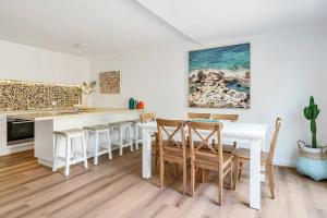 een keuken en eetkamer met een witte tafel en stoelen bij Bronte Haven - Coastal Bliss for Families in Sydney