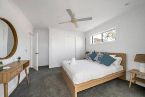 een slaapkamer met een bed en een plafondventilator bij Bronte Haven - Coastal Bliss for Families in Sydney
