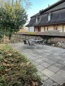 un patio con 2 sillas y una mesa frente a una casa en Zimmer mit geteiltem Bad & Küche en Brugg