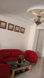 Appartement centre ville في لاراش: غرفة معيشة مع أريكة حمراء وطاولة