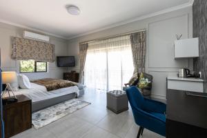 1 dormitorio con cama, escritorio y ventana en The African Penguin Guesthouse, en Pretoria