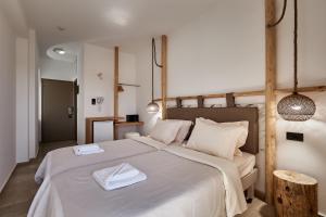 a bedroom with a large bed with two towels on it at Asana Hotel in Hersonissos +27 photos