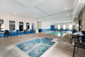 a large swimming pool with a bathtub in a building at Best Western Plus Moosomin Hotel in Moosomin