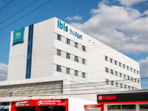 ibis budget Itaperuna في إيتابيرونا: مبنى أبيض مع علامة دلو الحافلة عليه