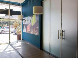 korytarz z niebieską ścianą i drzwiami w obiekcie ibis budget Itaperuna w mieście Itaperuna