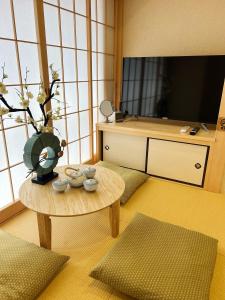 uma sala de estar com uma mesa e uma televisão de ecrã plano em akihabara k em Tóquio