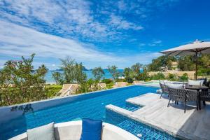 a pool with a table and chairs and an umbrella at Banyan Tree Krabi in Tab Kaek Beach