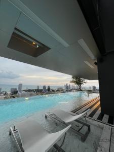 a swimming pool with chairs and a view of the city at Once Pattaya in Pattaya Central