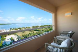 Pokój z 2 krzesłami i dużym oknem w obiekcie Wyndham Grand Cancun All Inclusive Resort & Villas w mieście Cancún