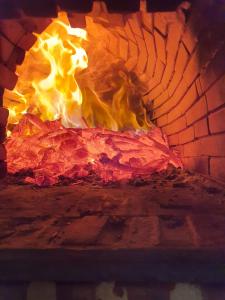 um fogo num forno de tijolos com chamas em LA CASA DEL HORNO em Hornedo