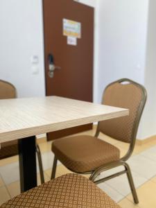 una mesa y sillas con una mesa y una puerta en Hotel Opal Superior - Adults Only, en Gyöngyös