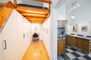 a kitchen with white cabinets and a black and white checkered floor at Shining bright two bedroom apt next to Andrassy ave in Budapest