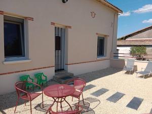 a patio with a table and chairs and a building at Les gîtes de Camarel in La Plaine