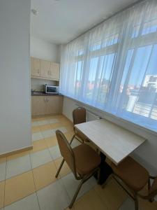 a kitchen with a table and chairs and windows at Hotel Opal Superior - Adults Only in Gyöngyös
