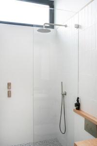 La salle de bains est pourvue d'une douche avec une porte en verre. dans l'établissement 'The Honeycomb' Experience Passive Nordic Design, à Sydney