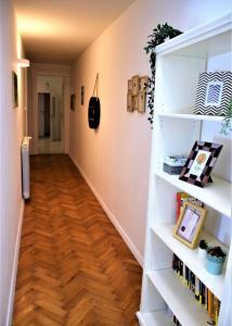 um corredor com prateleiras brancas e piso de madeira em Casa Vacanze Trieste Piace em Trieste