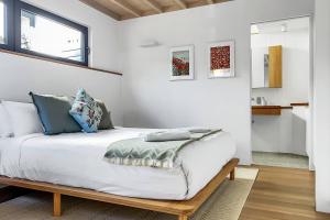 a bedroom with a large bed with white walls at 'The Honeycomb' Experience Passive Nordic Design in Sydney