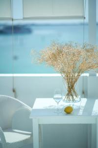 a white table with a vase of flowers and a wine glass at AVANTI Lifestyle Hotel - Only Adults in Corralejo