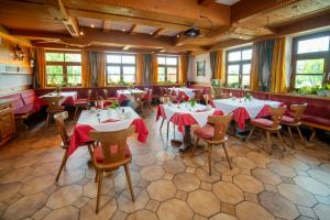 um restaurante com mesas e cadeiras com guardanapos vermelhos em Landhotel Hoisl-Bräu em Penzberg