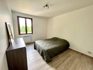 a bedroom with a bed and a desk and a window at Maison de campagne proche Disney in Chamigny