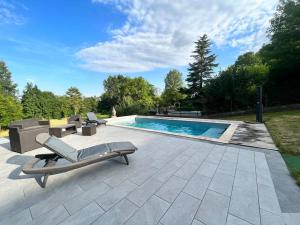 una piscina con chaise longue junto a en Maison de campagne proche Disney en Chamigny