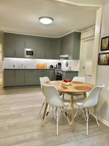 a kitchen with a wooden table and white chairs at Gjestehuset Borggata 18 in Fredrikstad