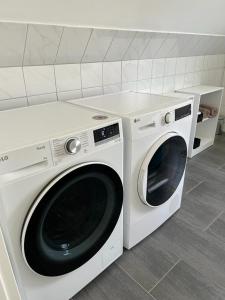 zwei weiße Waschmaschinen nebeneinander in einer Küche in der Unterkunft Domo Dolce Wohnapartment 