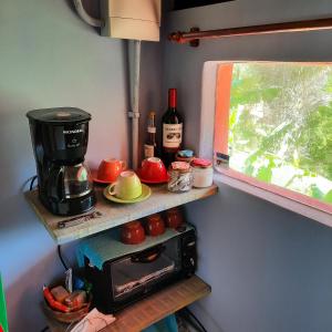 uma cozinha com comodidades para preparar café e um micro-ondas em Suítes Casinha do Alto da Bocaina em São Pedro da Serra