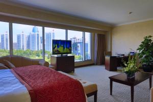 a hotel room with a bed and a flat screen tv at Beijing Continental Grand Hotel in Beijing