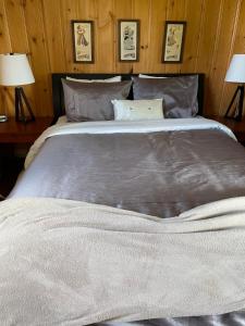 a large bed in a bedroom with two lamps at Chalets Plage St-Jean 2 in Saint-Jean