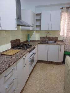a kitchen with white cabinets and a stove top oven at Apartamento Grande Subida San Diego Centro Ciudad in Cartagena