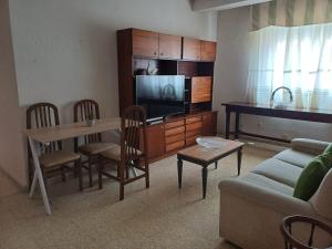 a living room with a couch and a table and a television at Apartamento Grande Subida San Diego Centro Ciudad in Cartagena