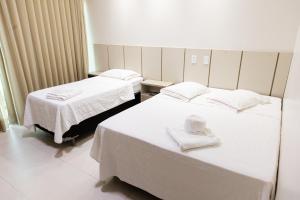 Dos camas en una habitación de hospital con toallas. en Pôr do Sol Hotel, en Santarém