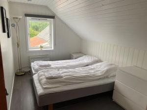 two beds in a small room with a window at Feriehus i landlige område med nydelig utsikt in Leirvik