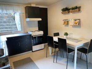 a kitchen with a white table and chairs in a kitchen at Feriehus i landlige område med nydelig utsikt in Leirvik