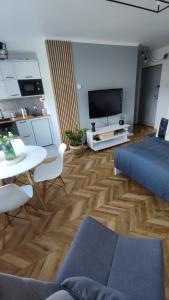 salon z niebieską kanapą i stołem w obiekcie Apartamenty Urban Concept w mieście Zamość