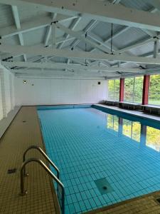 a large swimming pool with blue tiles on the floor at Haus enere Au in Todtmoos