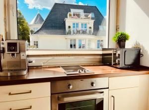 uma cozinha com um micro-ondas e uma janela com uma casa em Strand Studio mit Meerblick & Balkon em Lübeck