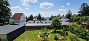 un jardín con un edificio con paneles solares en Innerpeace Vendégház, en Galyatető