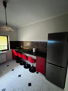 a kitchen with red and black counters and a refrigerator at Casa moderna in Mineri in Mineri