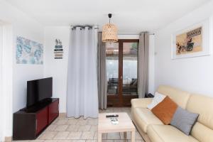 a living room with a couch and a tv at La Risle - Appartement spacieux in Brionne