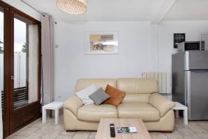 a living room with a couch and a table at La Petite Terrasse - Appartement spacieux in Brionne