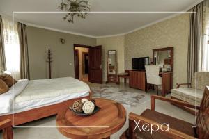 a bedroom with a bed and a table in a room at Boutique & Spa Hotel Heaven in Velingrad